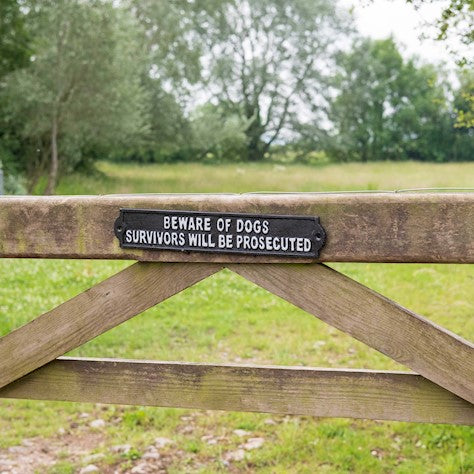 Heavy cast iron 'BEWARE OF THE DOGS SURVIVORS WILL BE PROSECUTED' sign