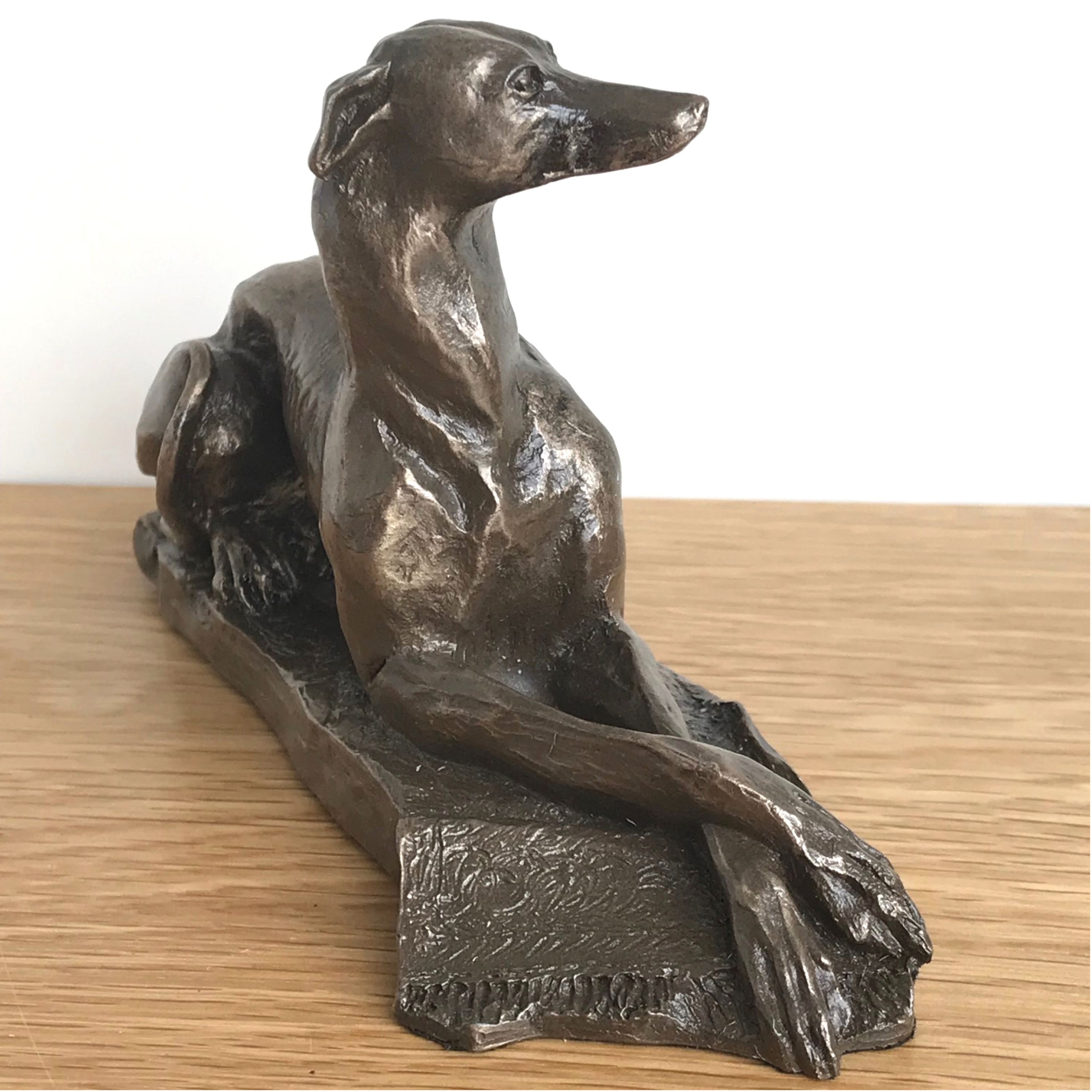 Laying Greyhound sculpture by Harriet Glen, in quality Cold Cast Bronze