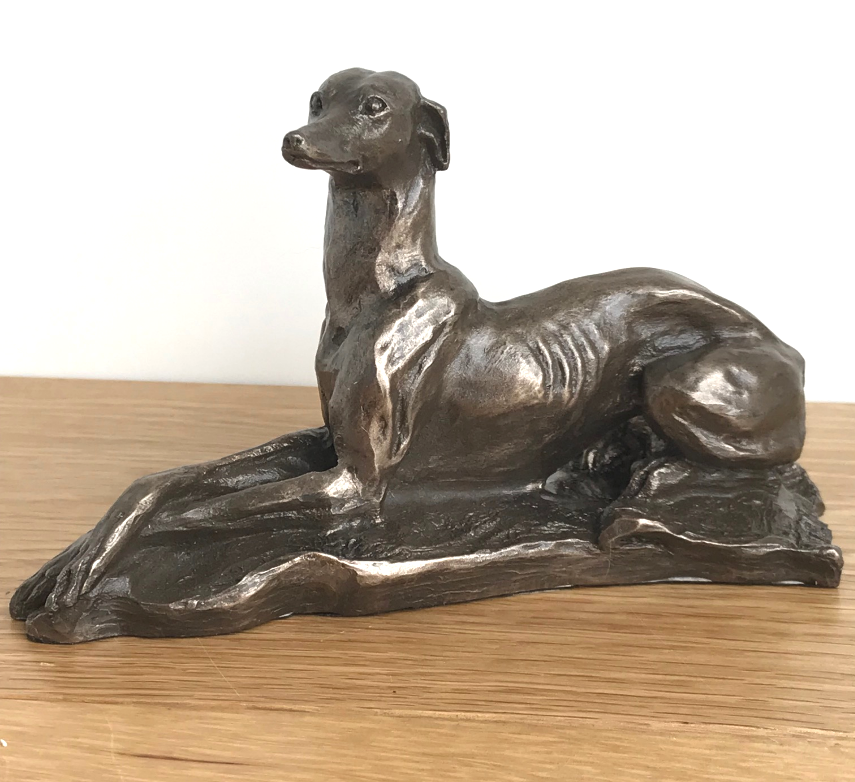 Laying Greyhound sculpture by Harriet Glen, in quality Cold Cast Bronze