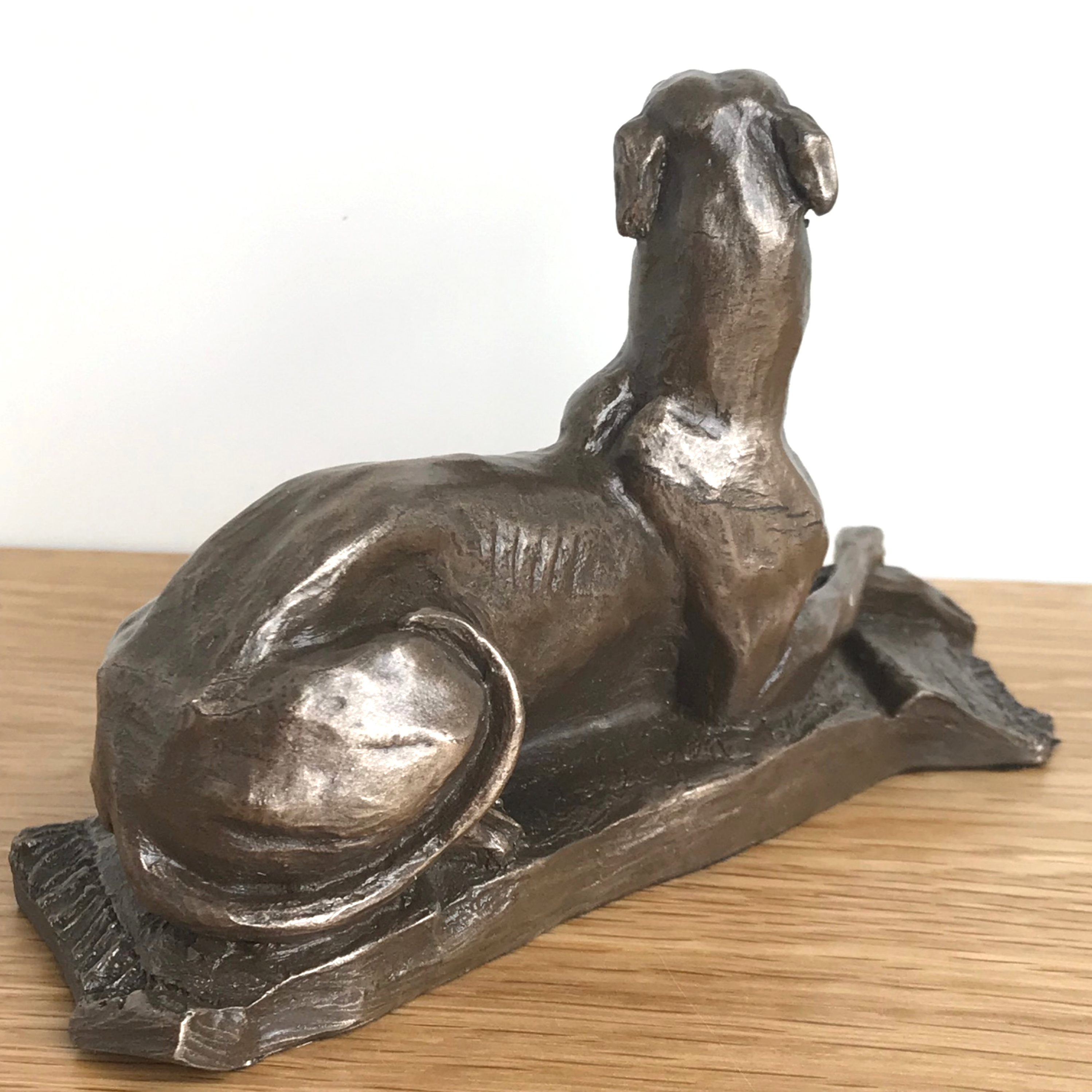 Laying Greyhound sculpture by Harriet Glen, in quality Cold Cast Bronze